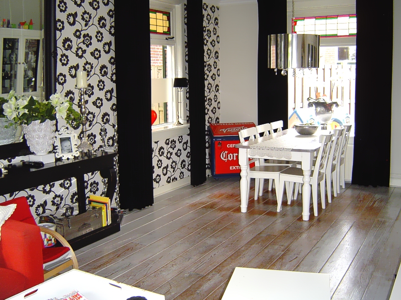 Woonkamer met zwart-wit behang en eettafel