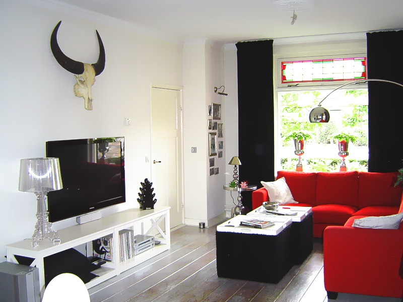 Woonkamer met tv-meubel en rode hoekbank